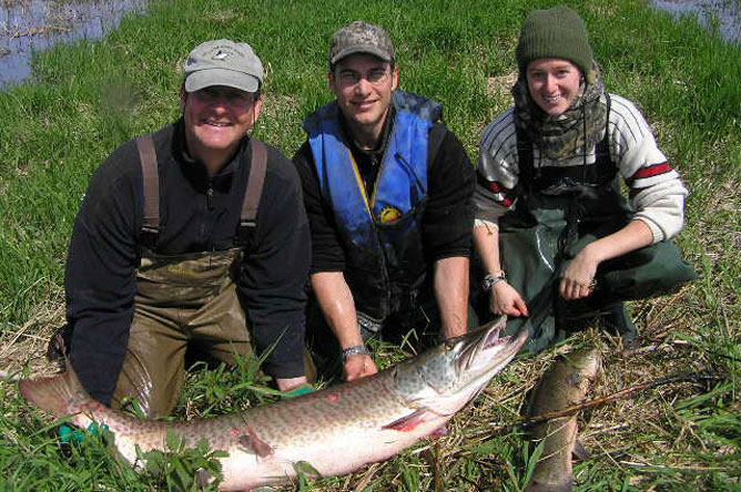 A woman and two men with a Muskellunge