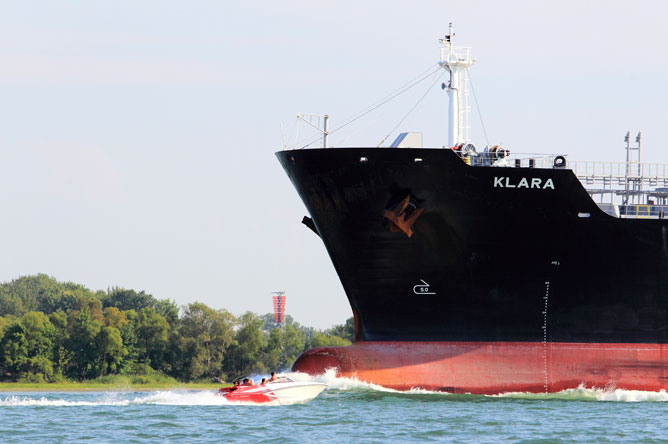 Navire commercial de taille imposante croisant un bateau de plaisance sur le fleuve Saint-Laurent.