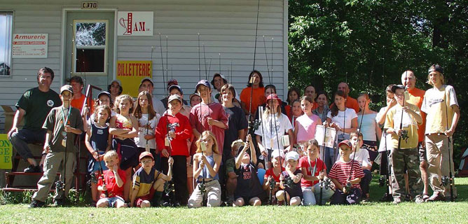 Plusieurs enfants avec des cannes à pêche lors du tournoi de la relève