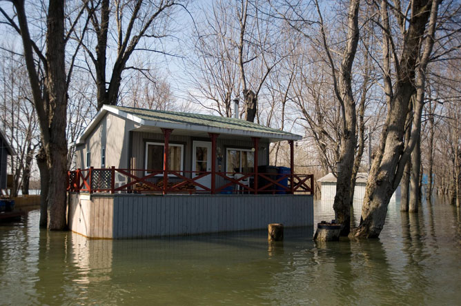 Light brown cabin on stilts during a spring flood
