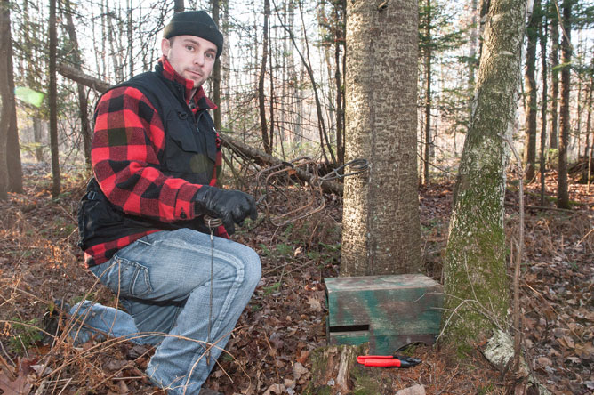 Man setting a trap in a wood.