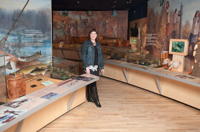 Michelle Bélanger montrant la maquette évoquant la pêche dans l'exposition permanente du Musée des Abénakis.