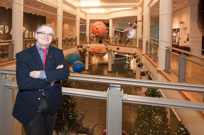 Yvon Noël on the second floor of the museum, in front of the colourful objects in the main hall