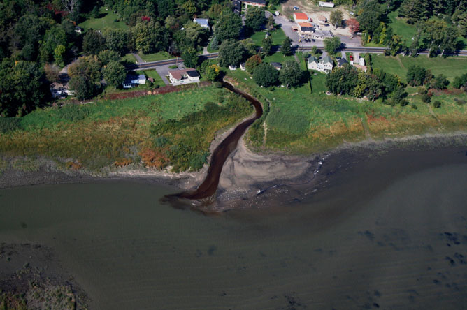 On voit la couleur brune de l'eau sur cette photographie aérienne de la rivière Saint-Joseph se jetant dans le fleuve Saint-Laurent à la hauteur de Lanoraie.