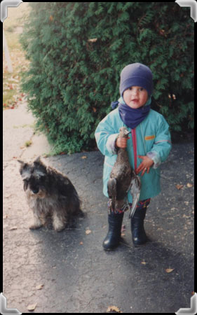 Young girl holding a dead duck.