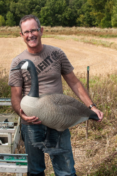 Man holding a Canada Goose decoy.