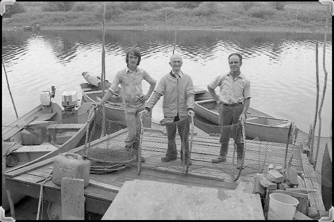 Des pêcheurs de Sainte-Anne-de-Sorel tenant un verveux sur le quai.